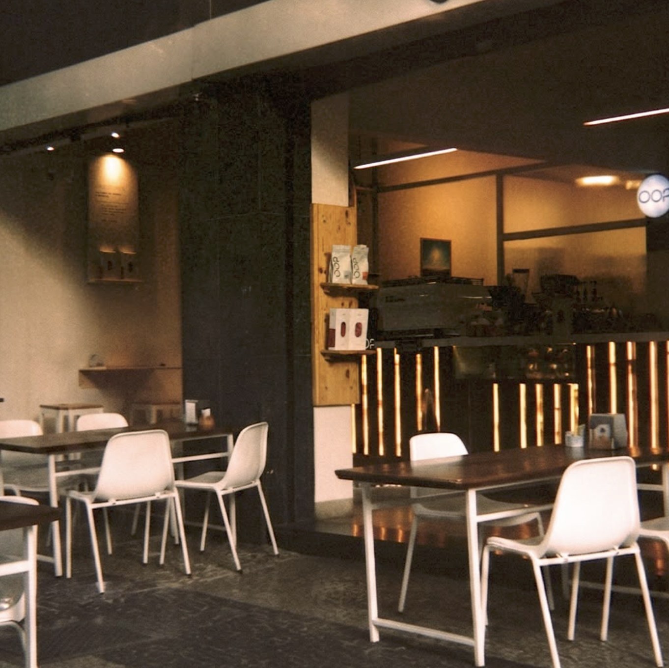 The storefront seating area and counter at OOP Café at night